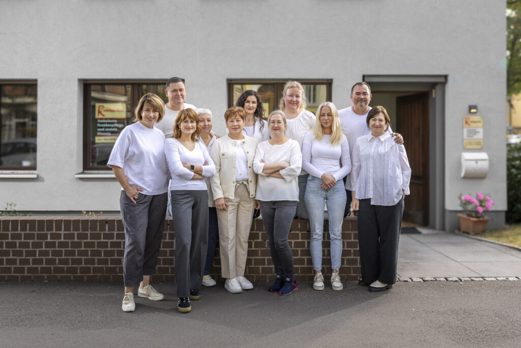 Gruppenfoto des Pflegedienstes Rotkäppchen vor dem Büro in Hannover – freundliches Team