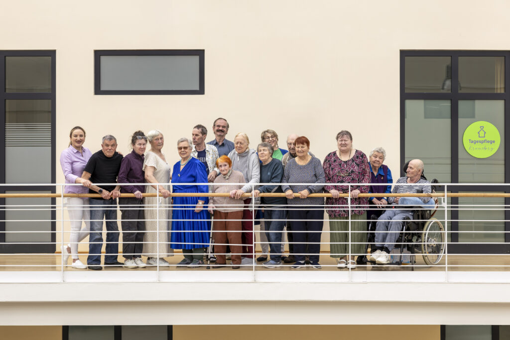Gruppe aus Gästen und Team auf dem Balkon der Tagespflege Kronsberg in Hannover – gemeinschaftlich, freundlich, barrierearm.