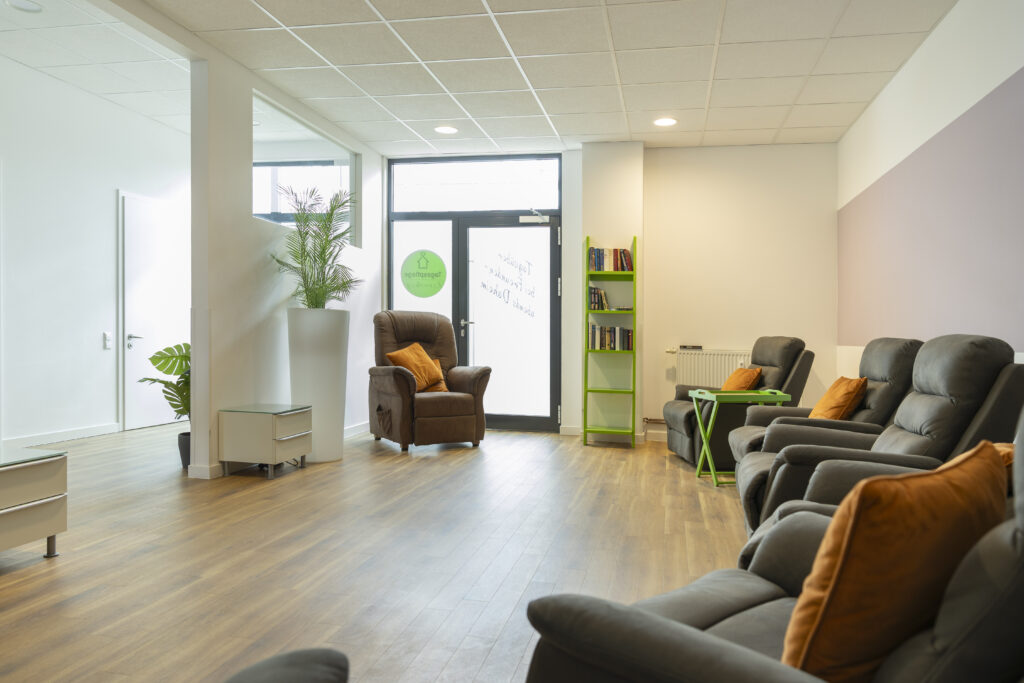 Heller Aufenthaltsbereich der Tagespflege Kronsberg mit bequemen Sesseln, klaren Wegen und ruhigen Ecken.